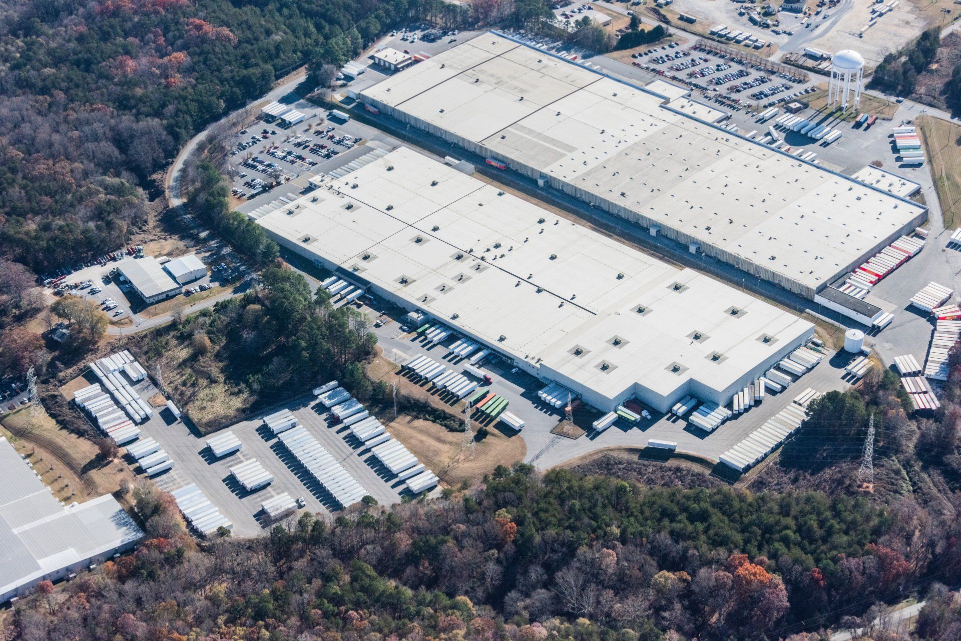 An aerial view of a large warehouse surrounded by trees.