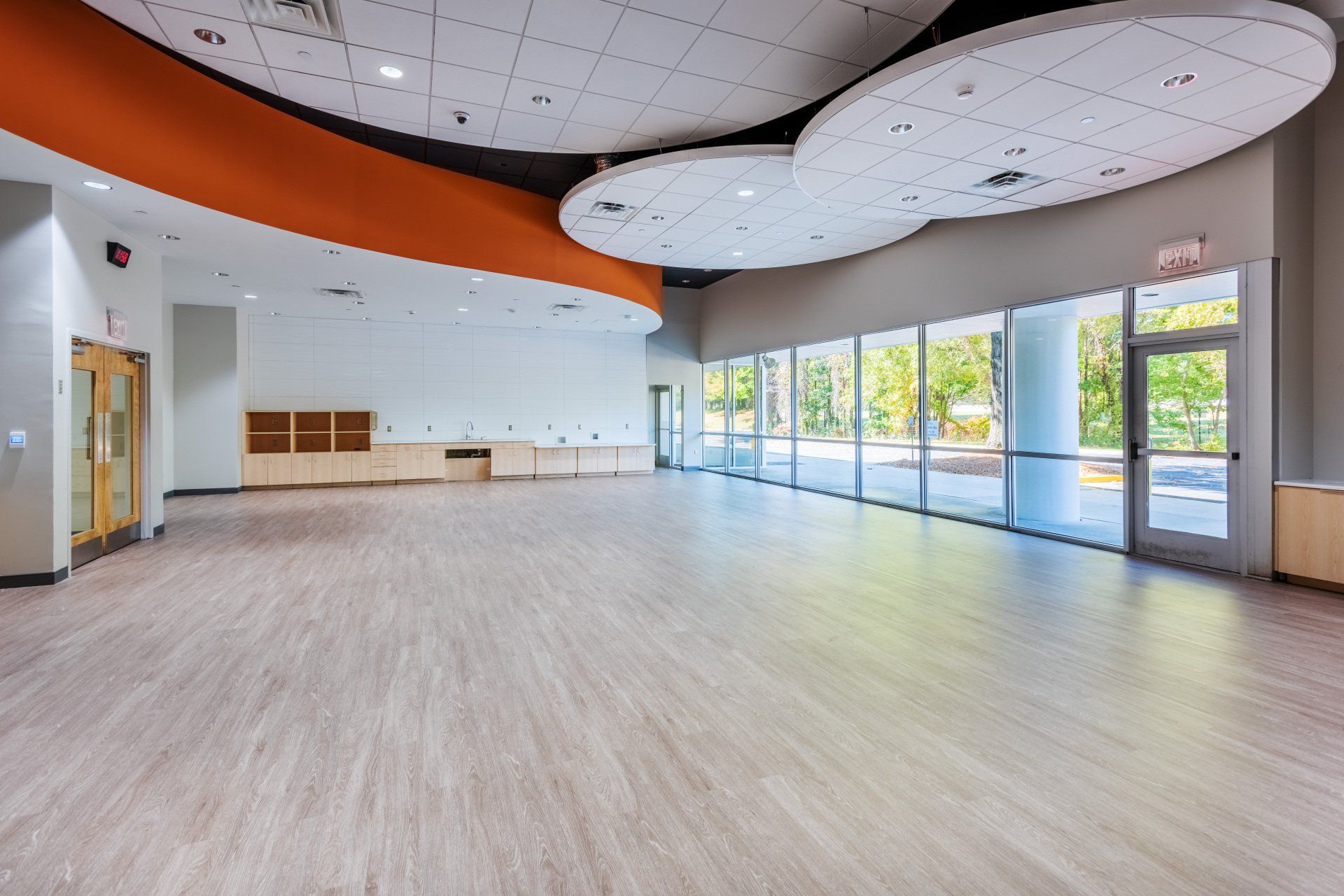 An empty room with a lot of windows and a wooden floor.