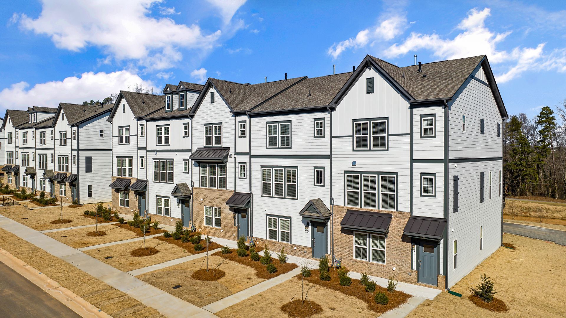 An aerial view of a row of apartment buildings on a sunny day.
