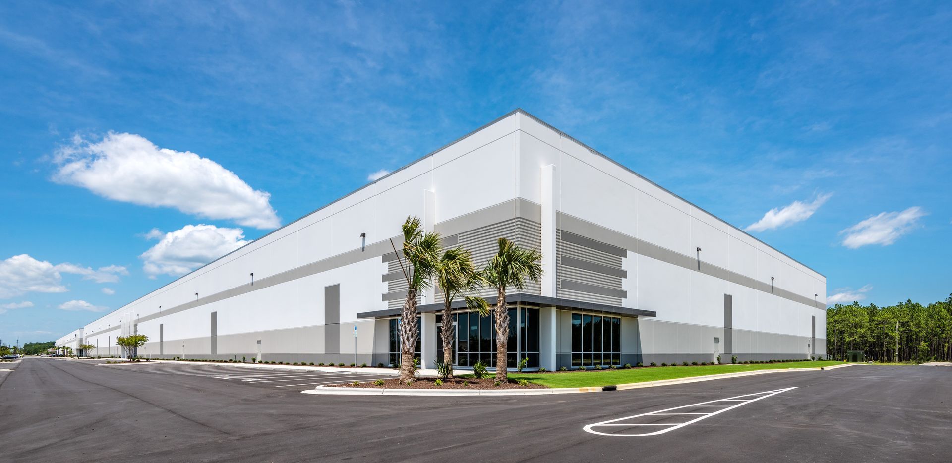 A large white building with a parking lot in front of it.