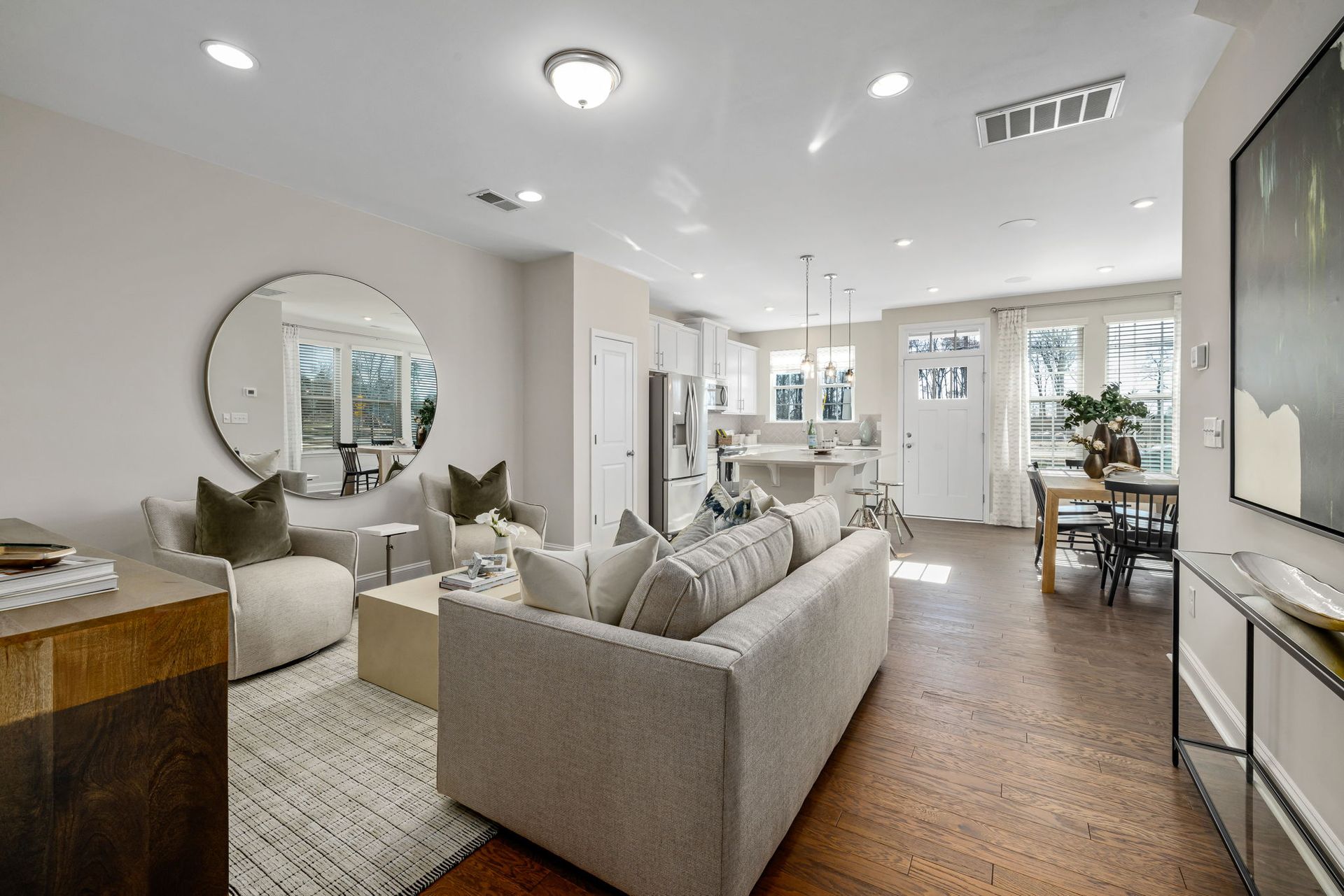 A living room filled with furniture and a large mirror.