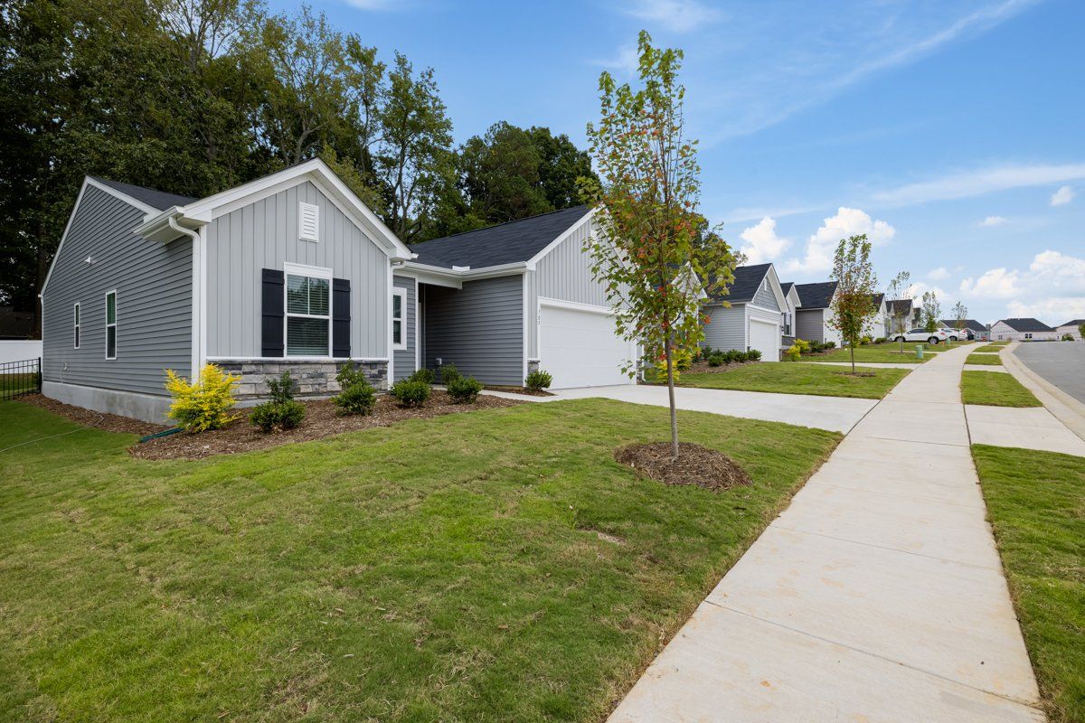 A row of houses with a sidewalk in front of them in a residential area.