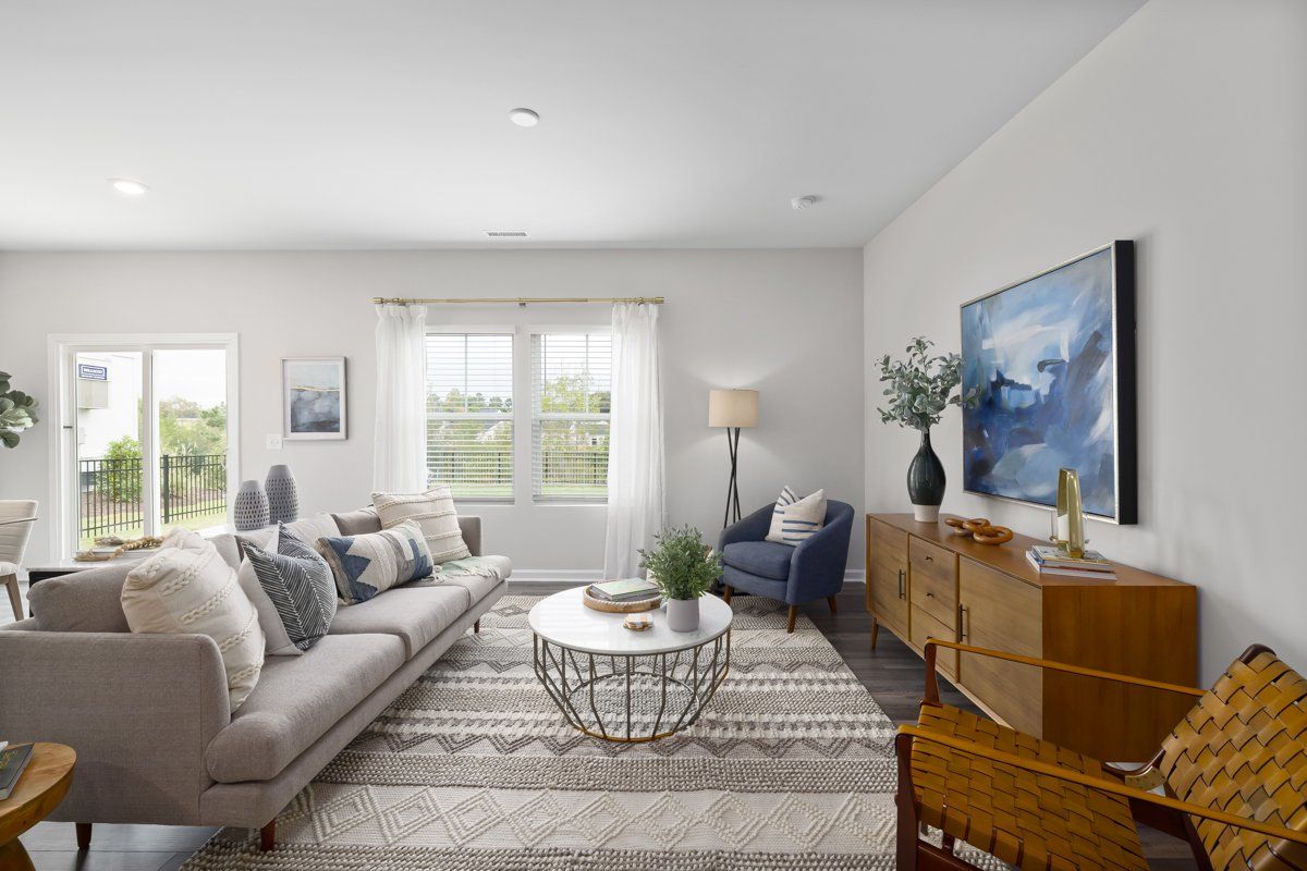 A living room with a couch , chair , coffee table and television.