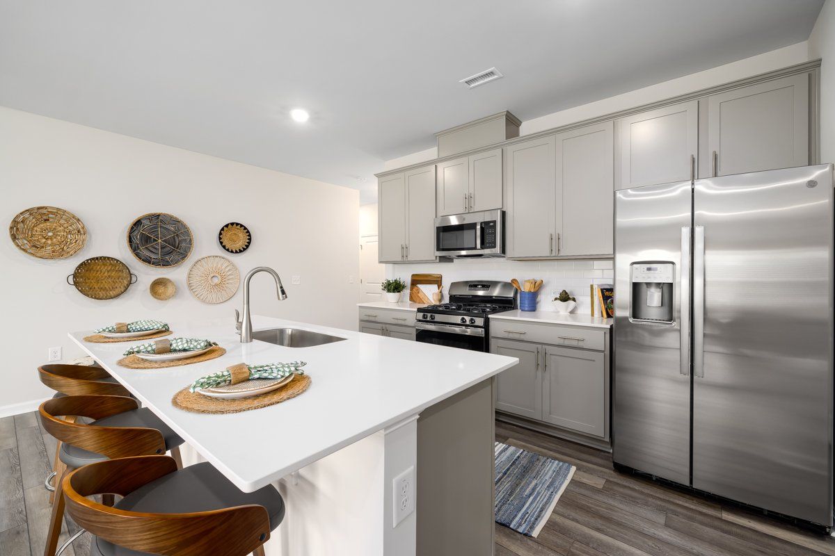 A kitchen with stainless steel appliances , a stove , a refrigerator , and a sink.