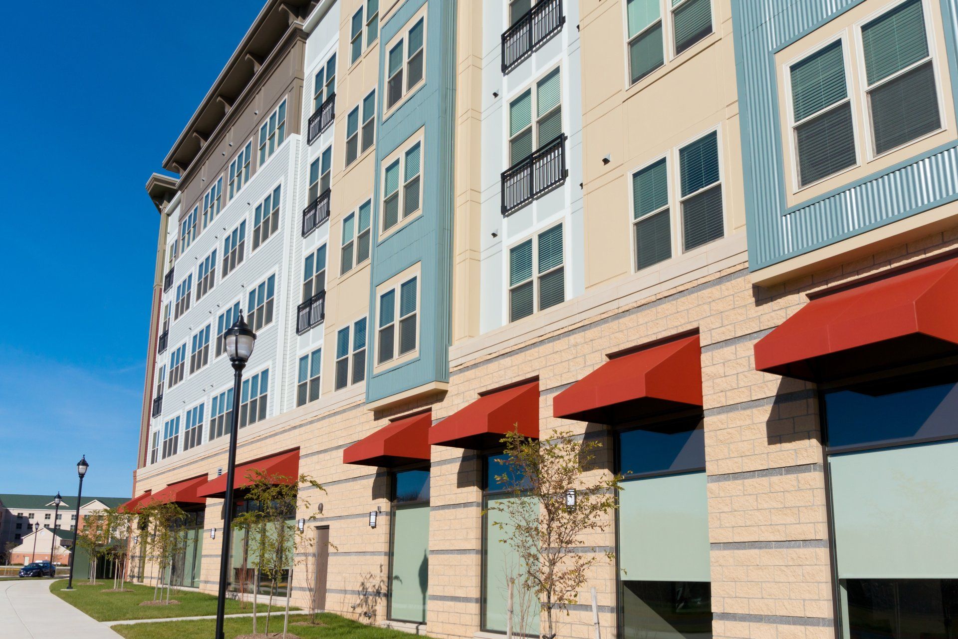 A large apartment building with red awnings on the windows.