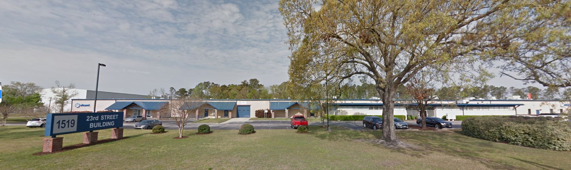A large building with a blue sign in front of it.