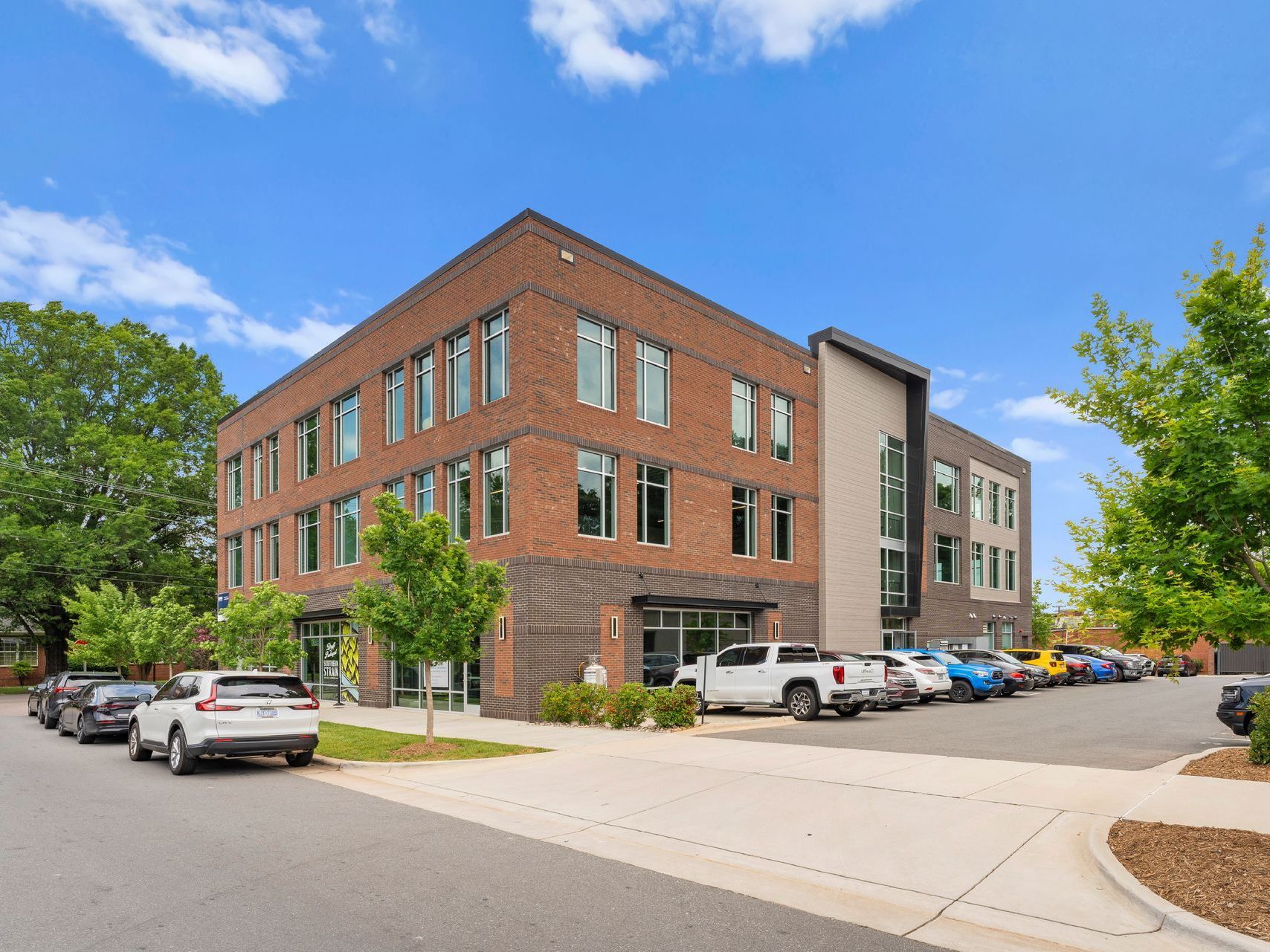 A large brick building with a lot of cars parked in front of it.