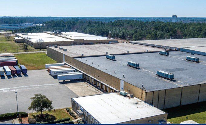 An aerial view of a warehouse with trucks parked in front of it