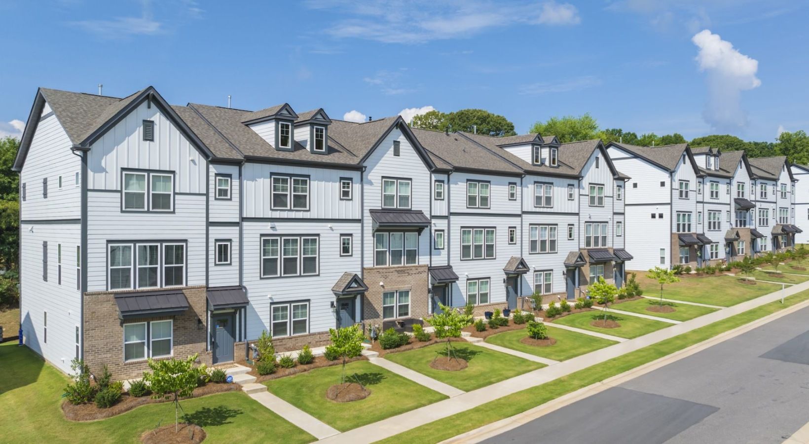A row of apartment buildings sitting next to each other on a sunny day.