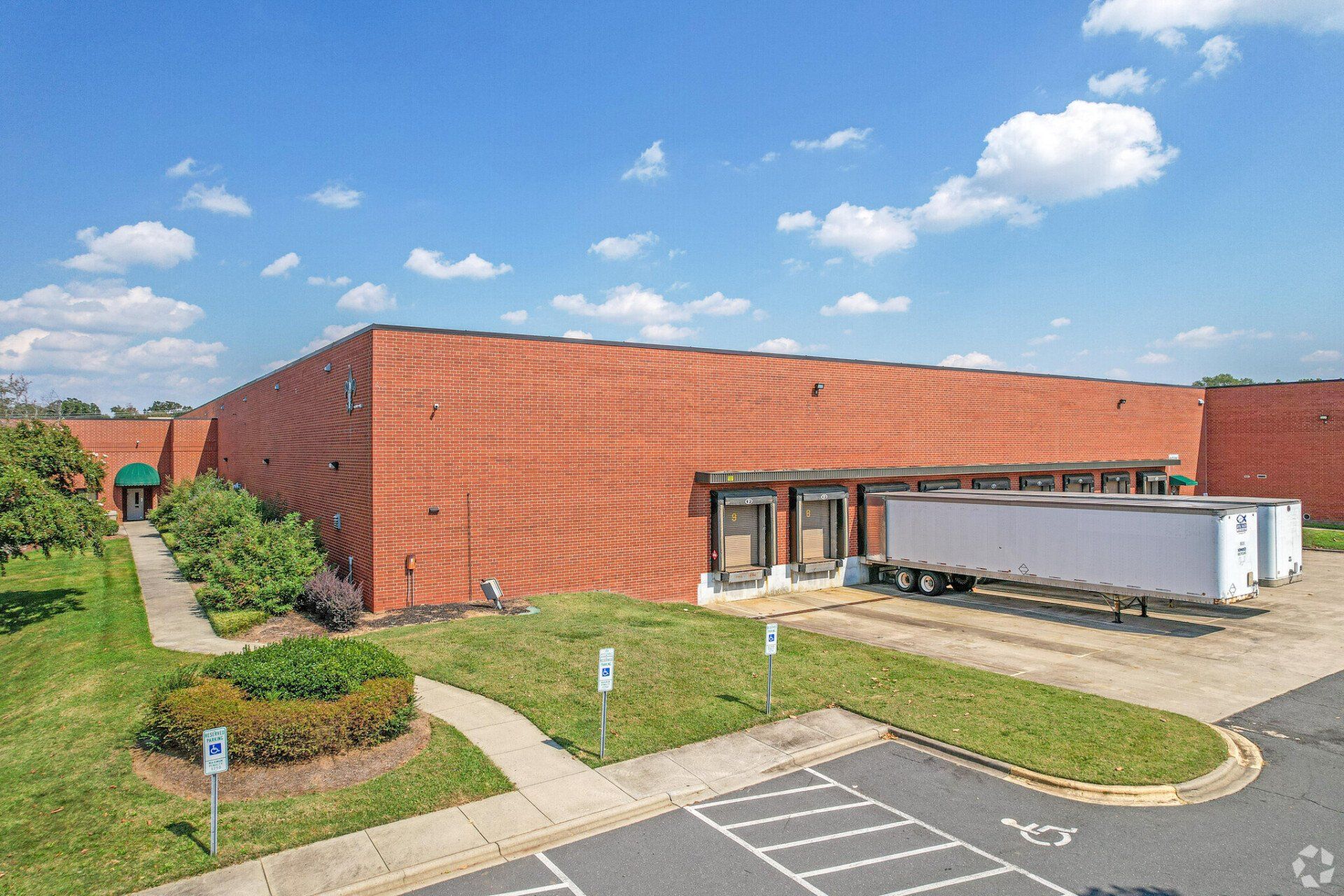 A large brick building with a white truck parked in front of it.