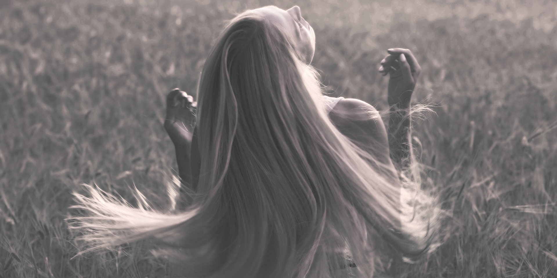 woman in field with long flowing blonde hair