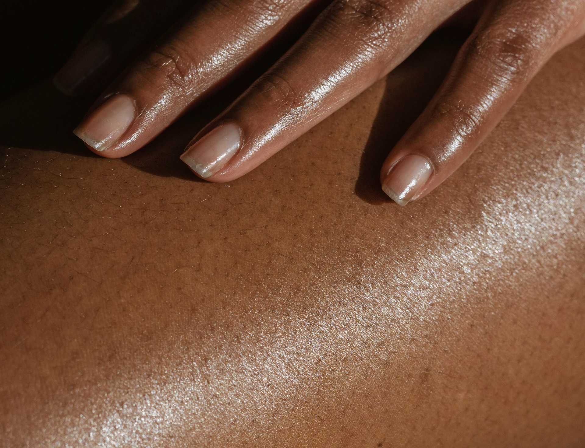 Close up image of hand on bare skin leg hydrated skin