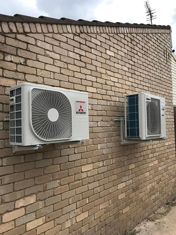 Two Air Conditioners are Mounted on a Brick Wall — Priest Airconditioning in Ashmont, NSW