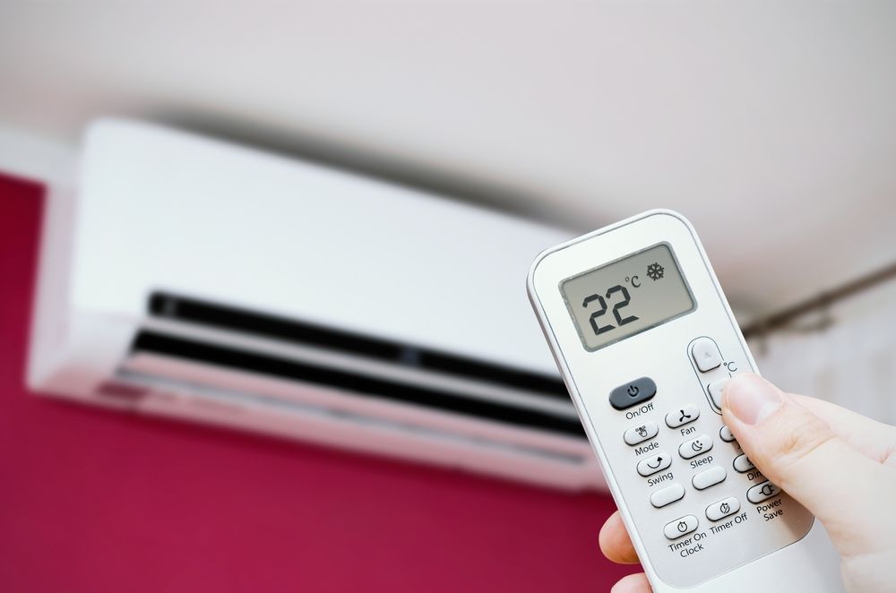 Hand Holding AC Remote — Priest Airconditioning in Tumut, NSW