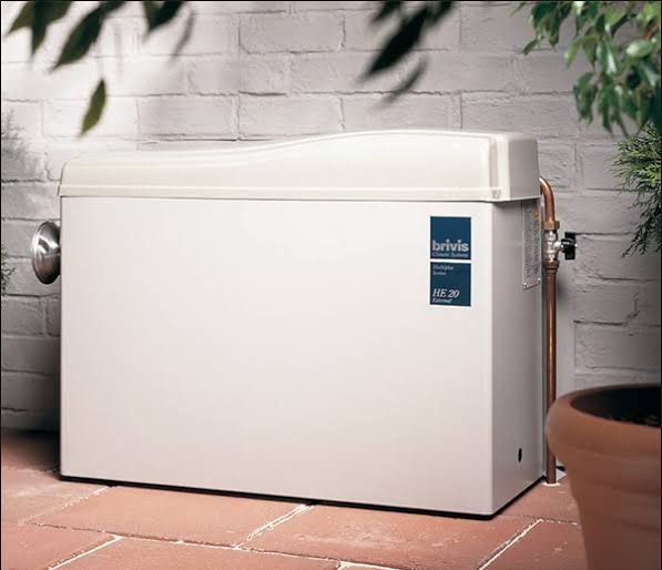 White Outdoor Boiler Next to a Brick Wall and Terracotta Pot — Priest Airconditioning in Ashmont, NSW