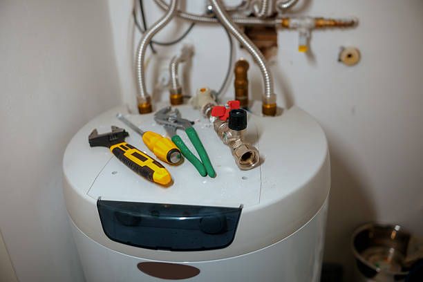 Tools on top of a white water heater in a utility room.