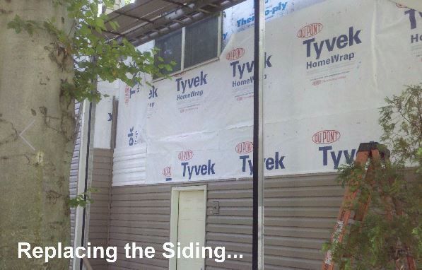 a ladder is being used to replace the siding on a house