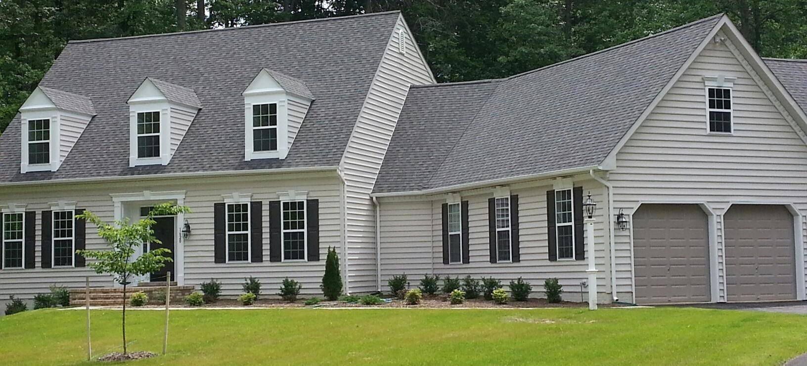 a white house with a gray roof and black shutters