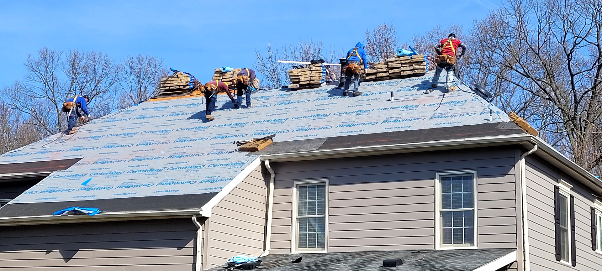 a group of people are working on the roof of a house