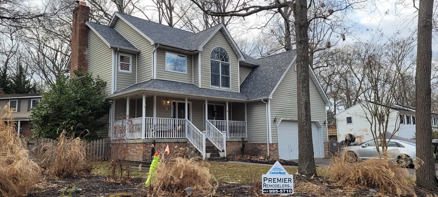 A large house with a gray roof is for sale.