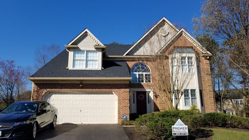 a large brick house with a car parked in front of it .