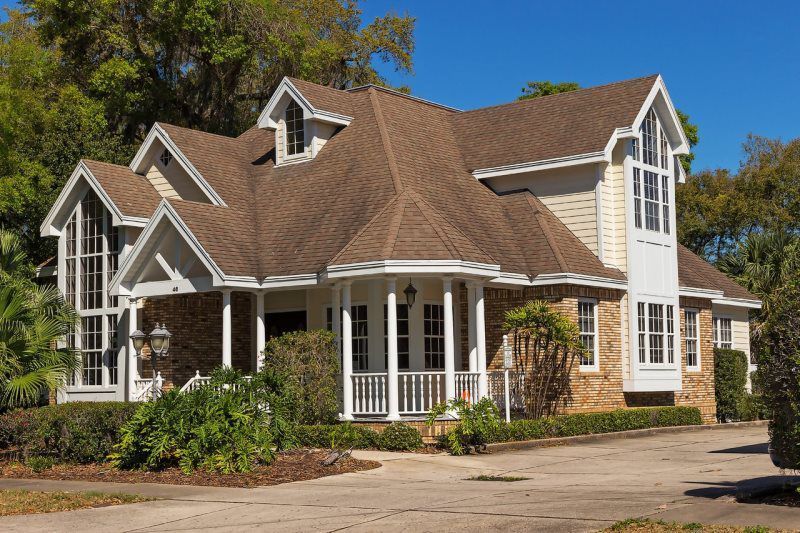 a large house with a brown roof and a large porch .