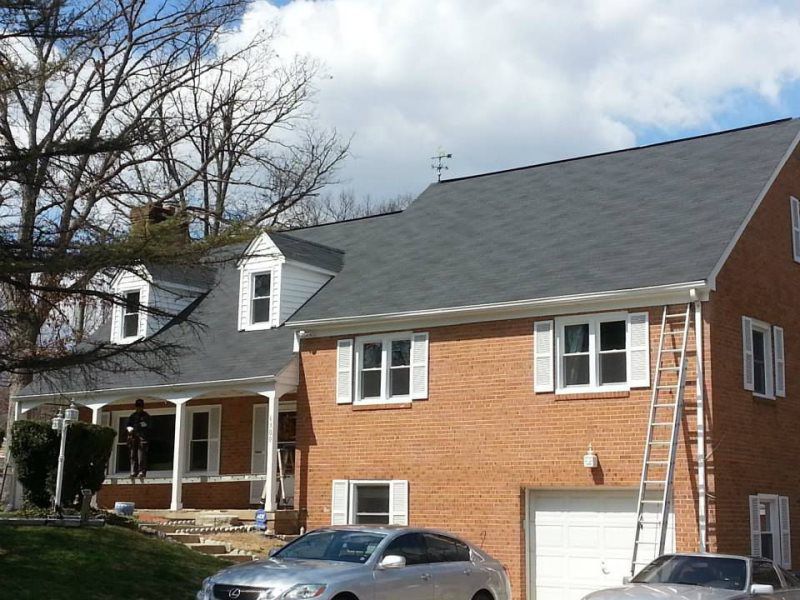 a silver car is parked in front of a brick house