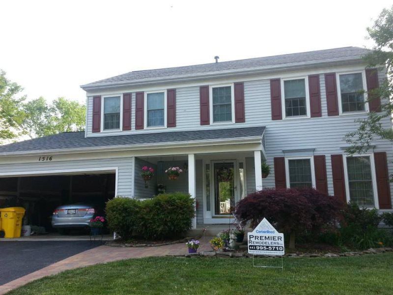a white house with red shutters is for sale