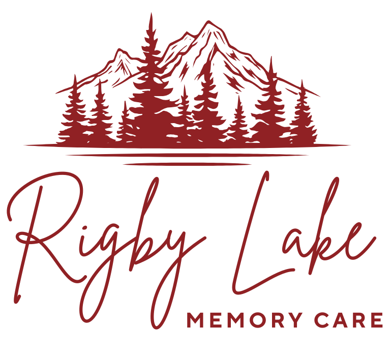 Logo for Rigby Lake Memory Care: Maroon mountain, pine trees, and cursive