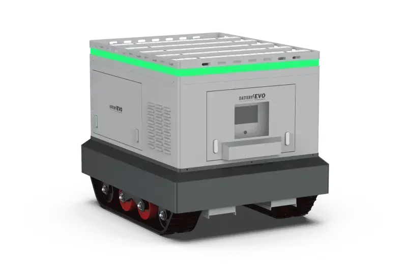 Gray industrial robot with green light, tank treads, in a warehouse setting.