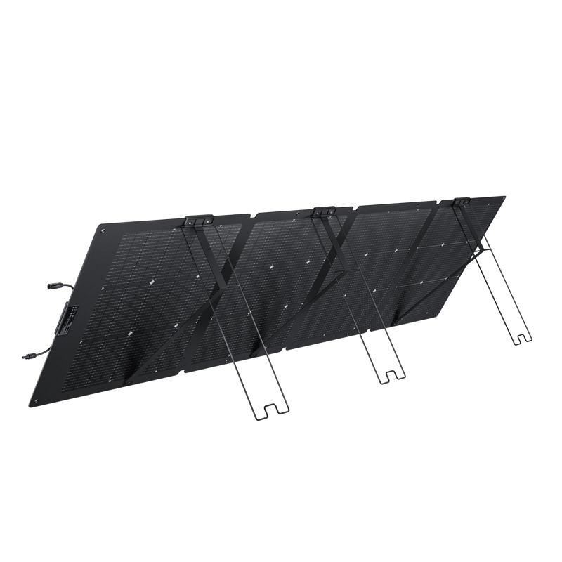 Foldable black solar panel with supporting stand, outdoors.