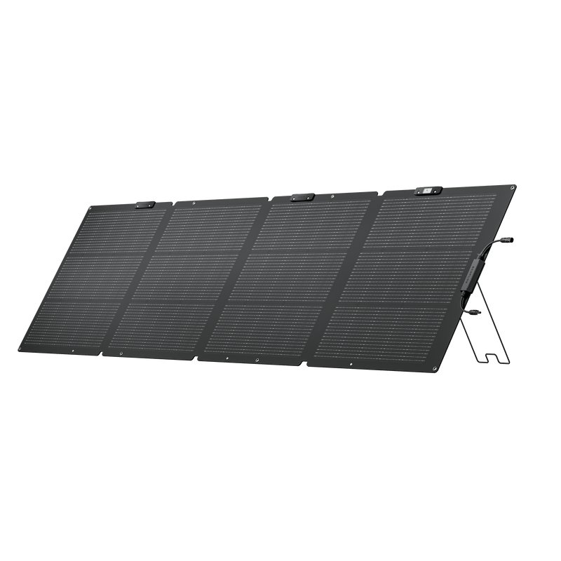 Foldable black solar panel with kickstand, set up outdoors.