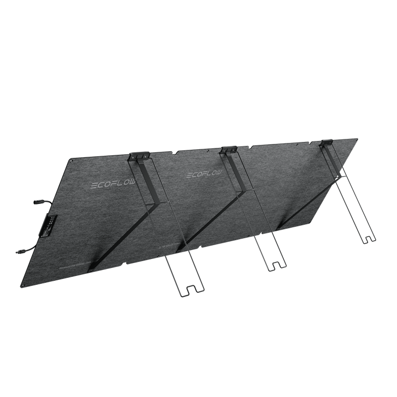 A black, foldable solar panel, propped up by a stand, positioned outdoors.