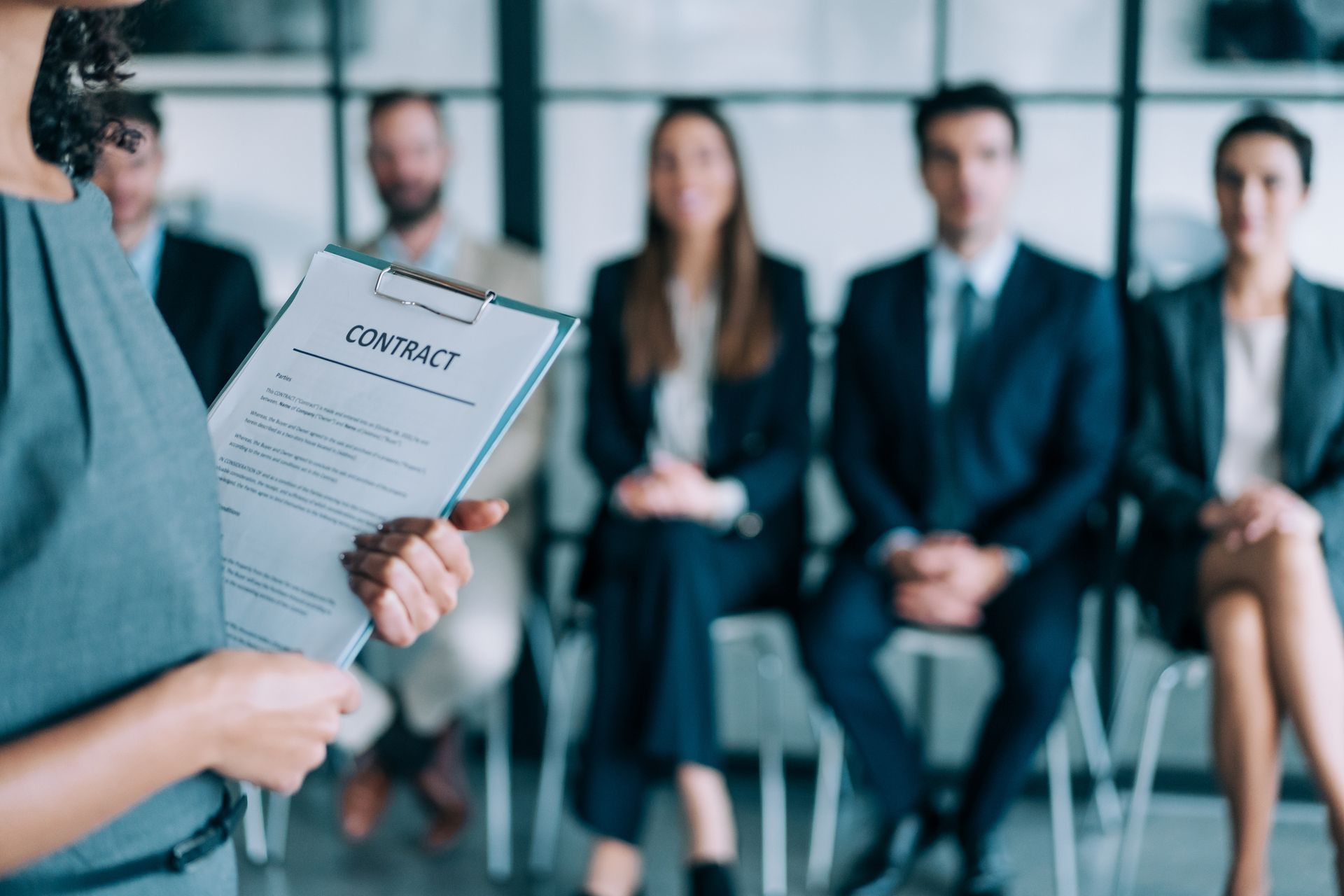 A Woman Is Holding A Clipboard With A Contract Papers — Riverton, UT — Great Basin Staffing LLC