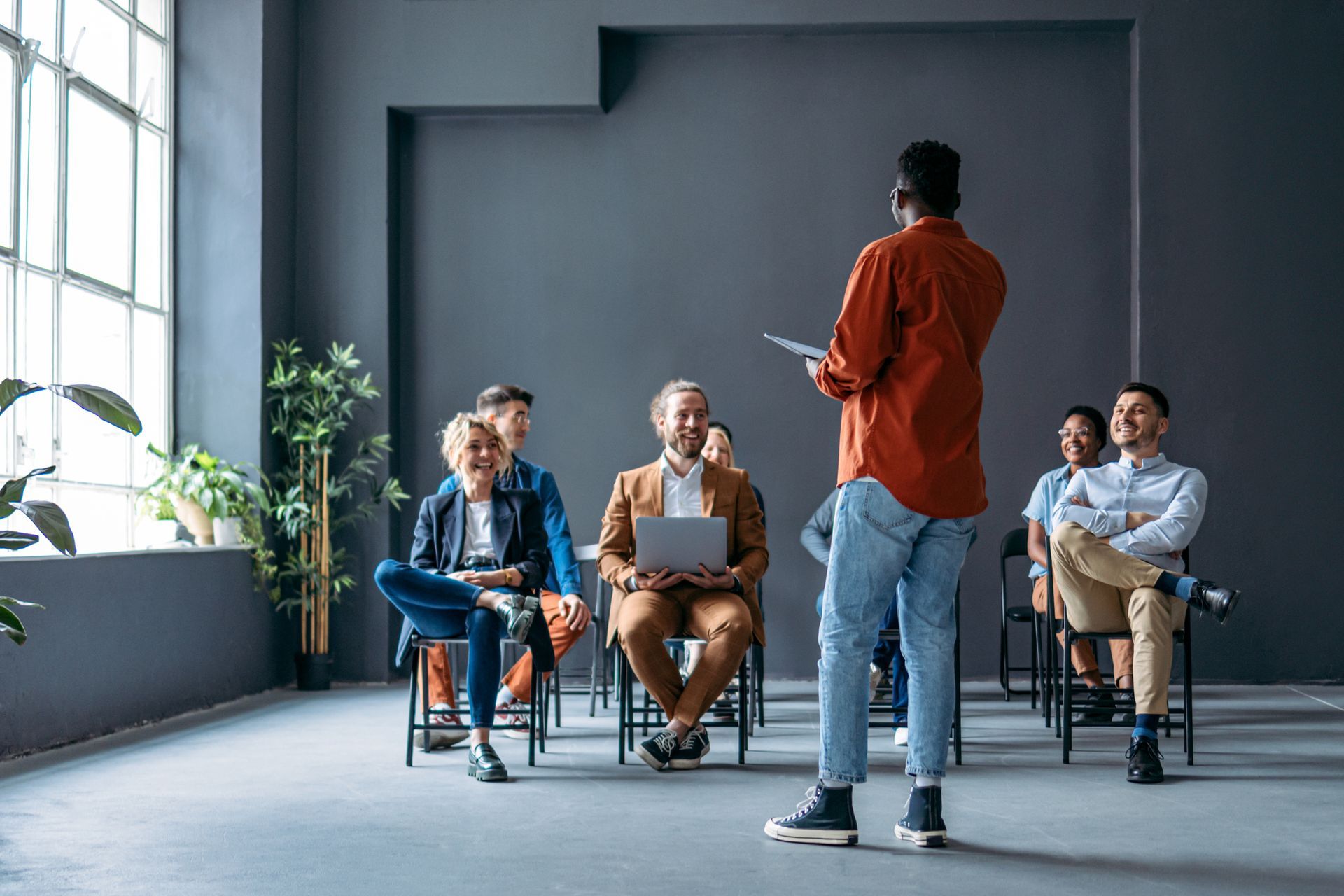 A Man Is Giving A Presentation To A Group Of People Sitting In Chairs — Riverton, UT — Great Basin Staffing LLC