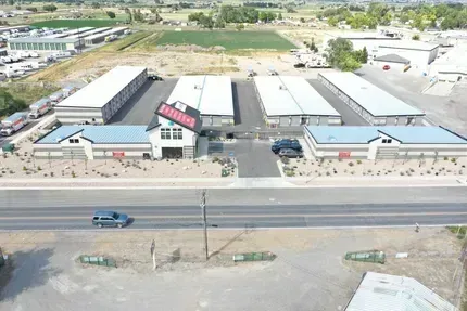 Aerial view of the PACA Self Storage facility in Payson, Utah showing fenced storage buildings, paved drive aisles and the office