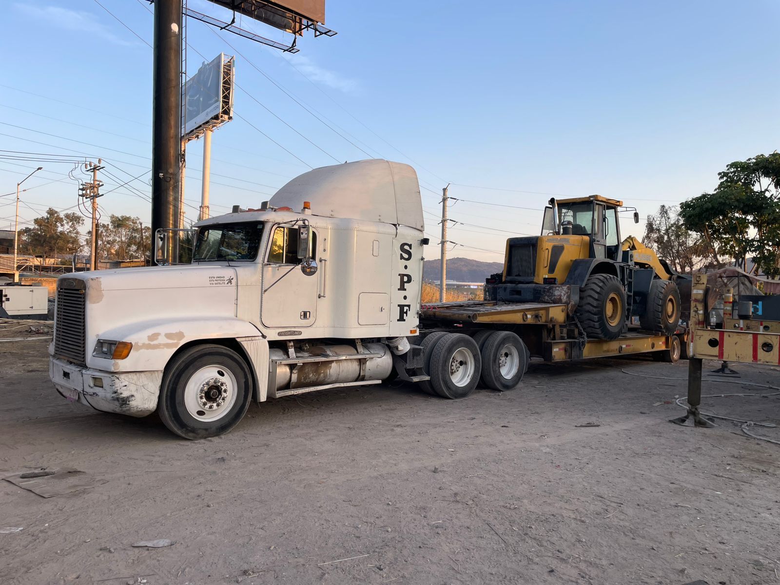 Trailer transportando en un lowboy un tractor