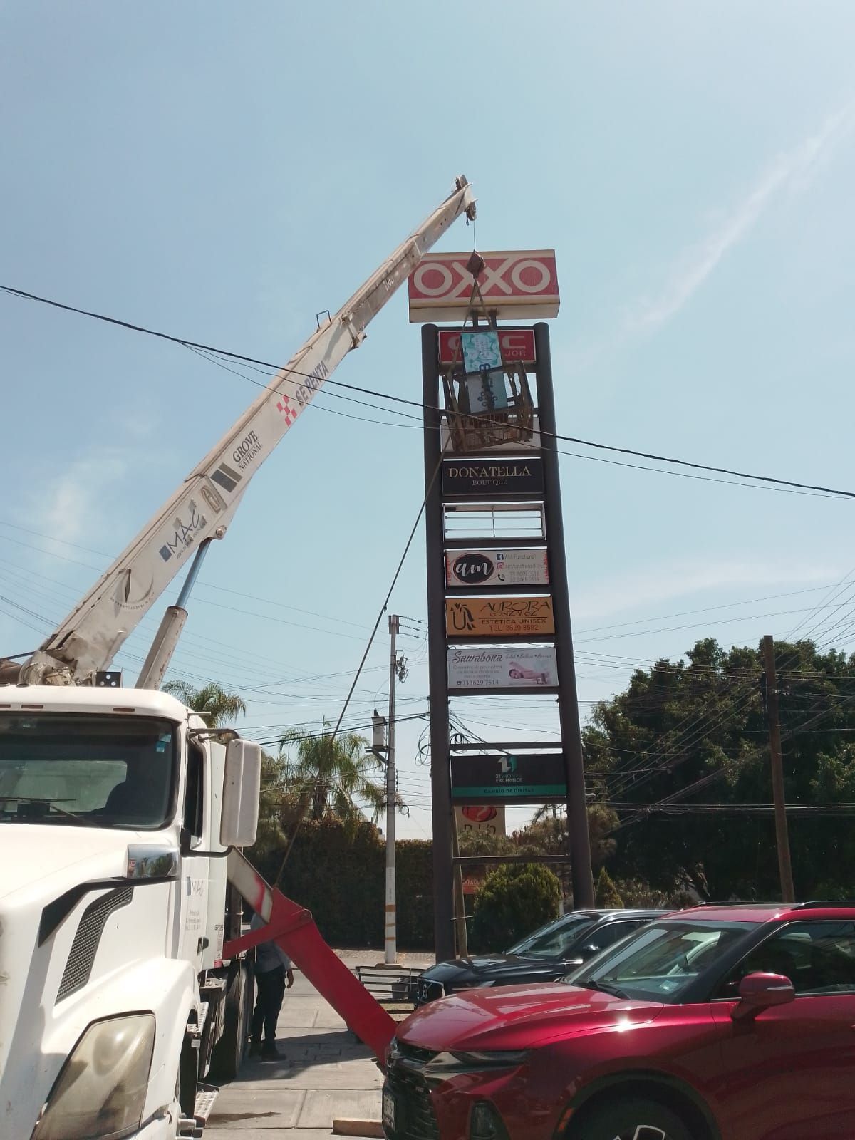 Grua titan montando anuncios de OXXO