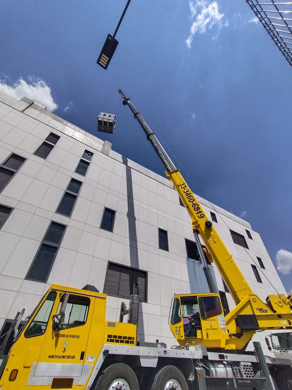 Grua Industrial suebiendo a centro comercial paquetes