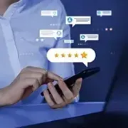 Person using smartphone with floating 5-star review and chat icons on a blue background