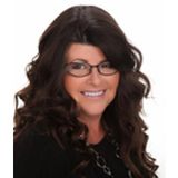 Smiling woman with long dark curly hair and black glasses on a white background