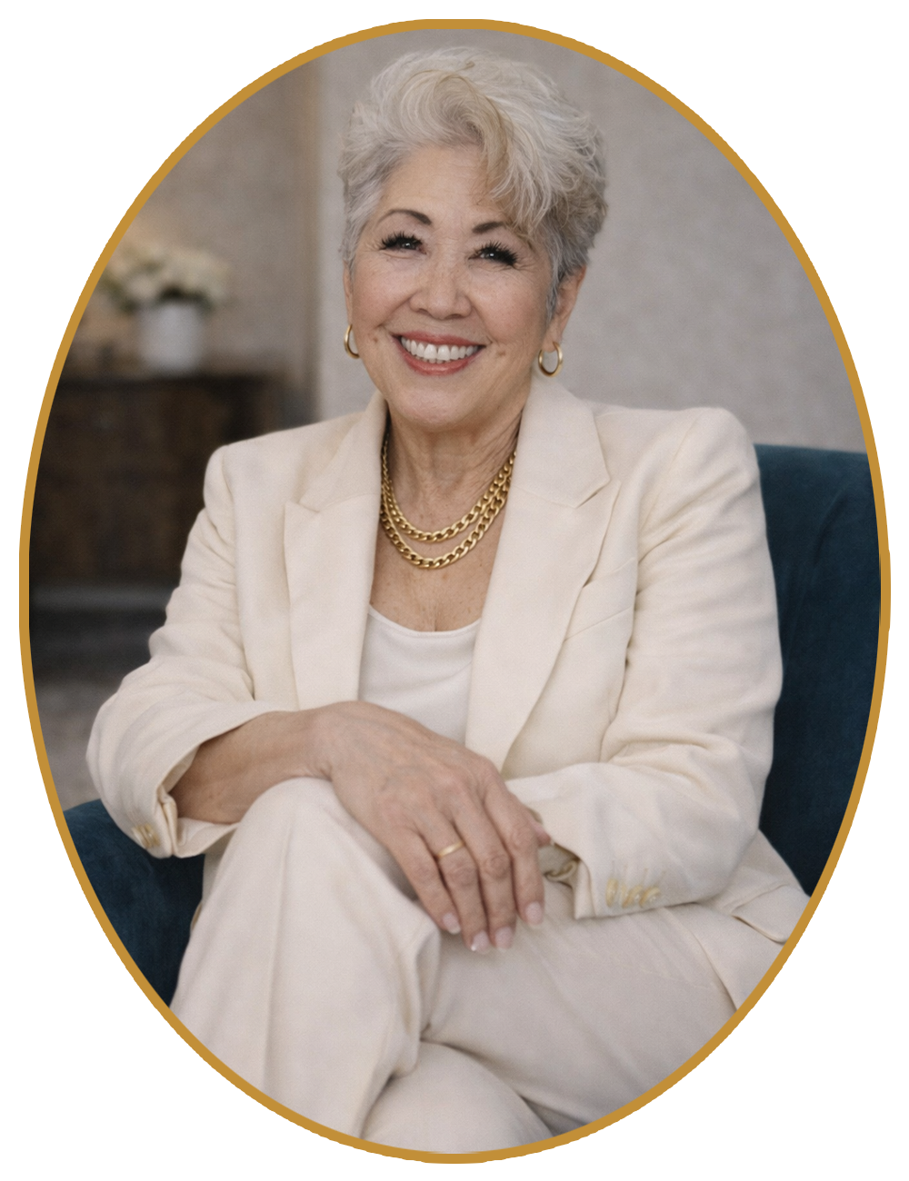 Smiling woman in a cream suit, seated with crossed legs against a neutral background.