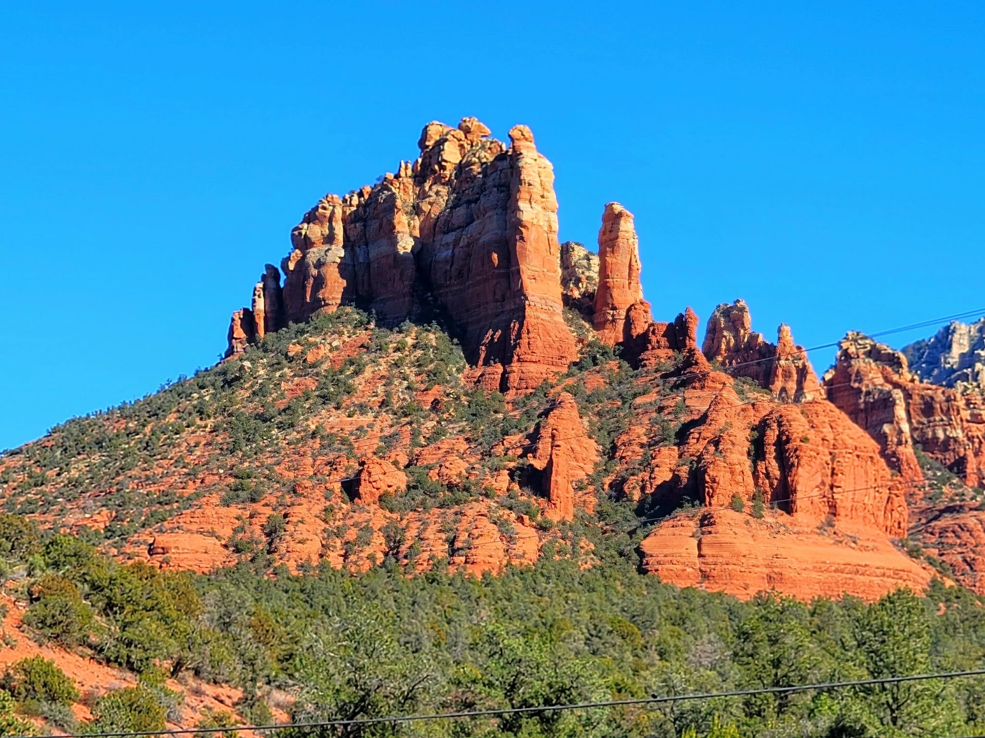 Red sandstone buttes and cliffs under a clear blue sky in a desert landscape
