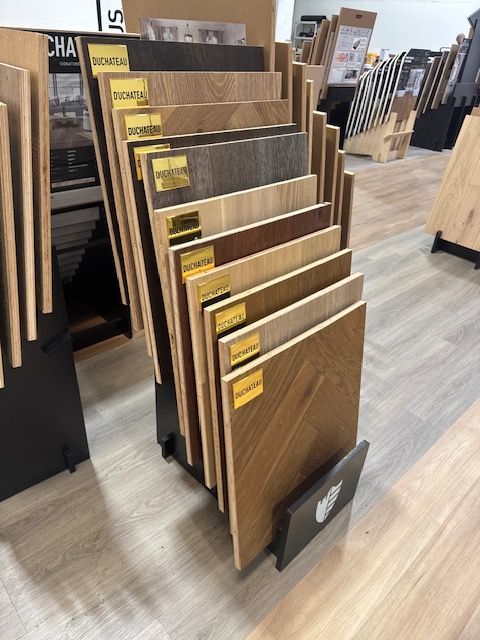 Wood sample display rack with assorted brown laminate panels in a showroom
