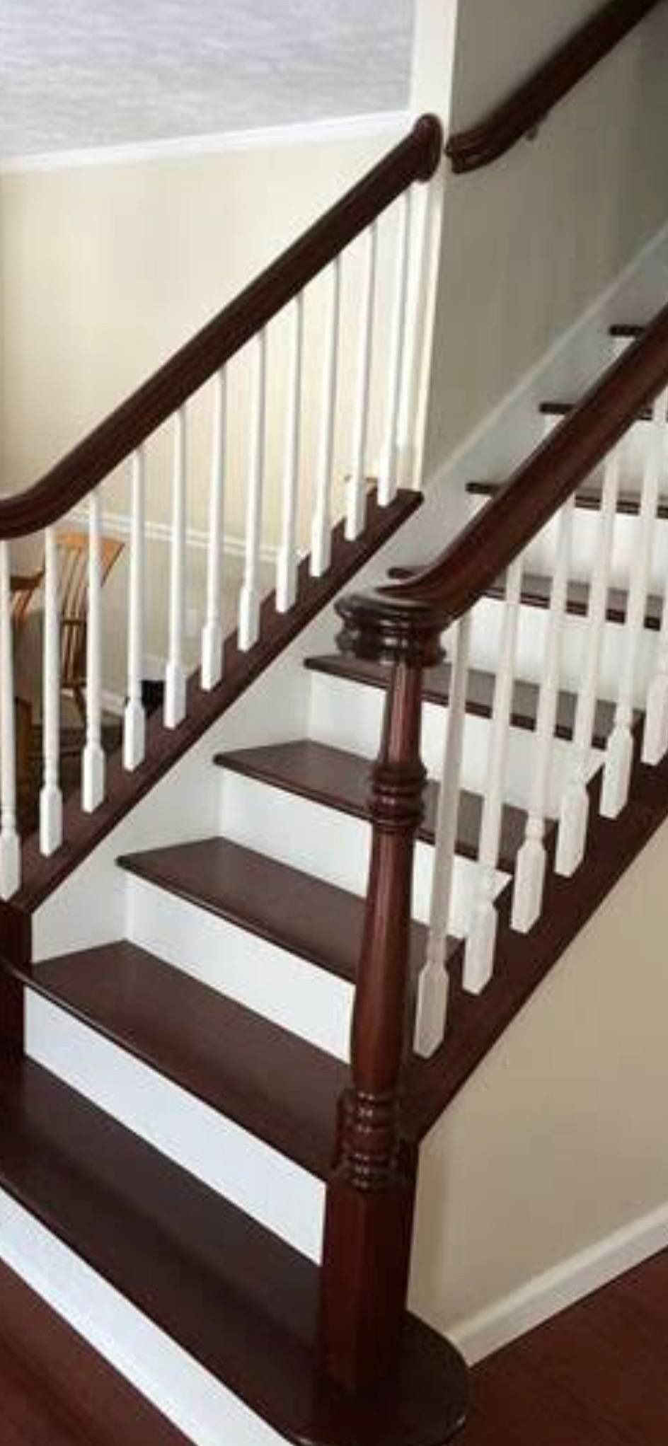 Wooden staircase with white spindles, dark wood handrails, and steps.