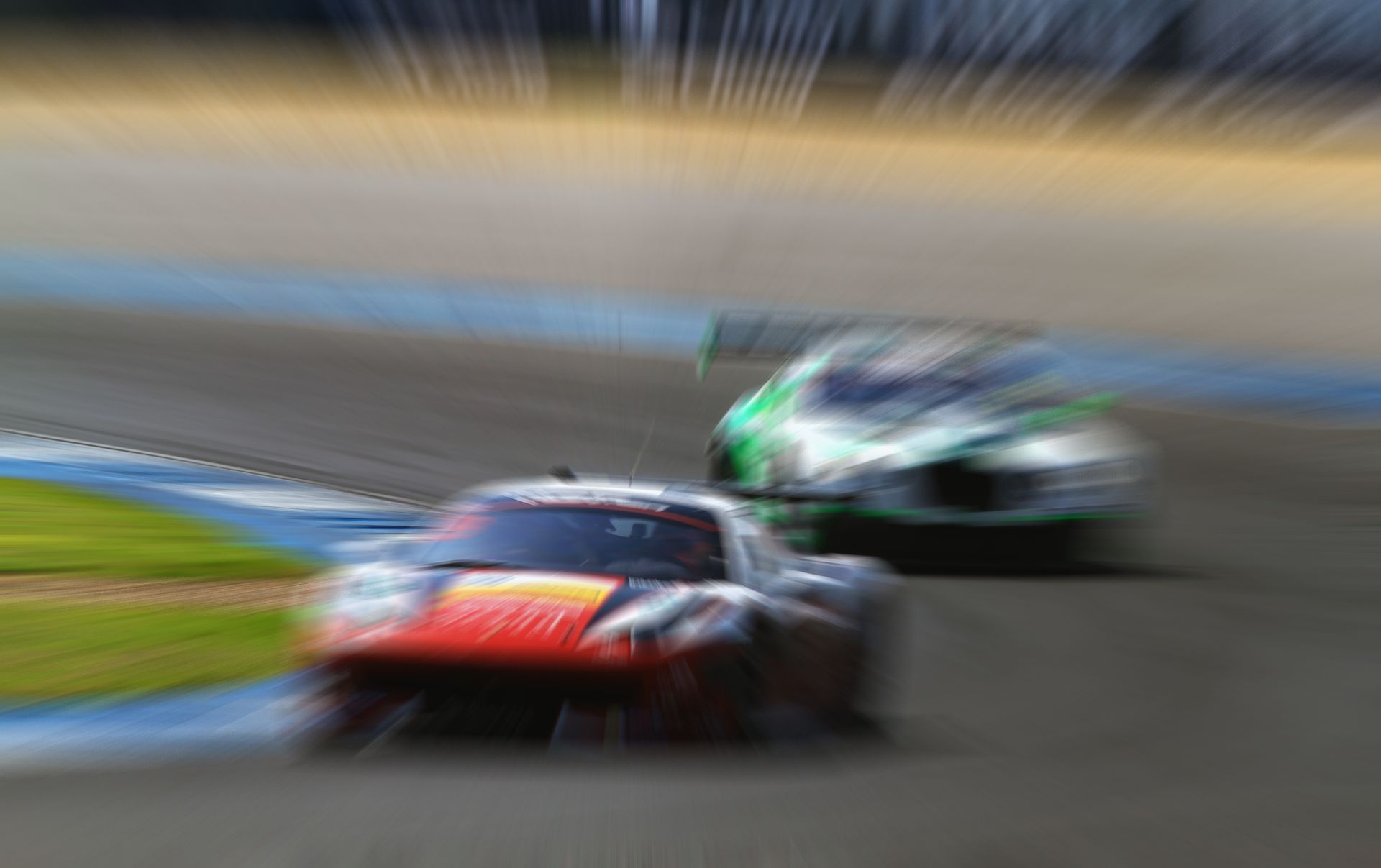 Blurred race cars speeding on a track, with a red car in front and a green car behind.
