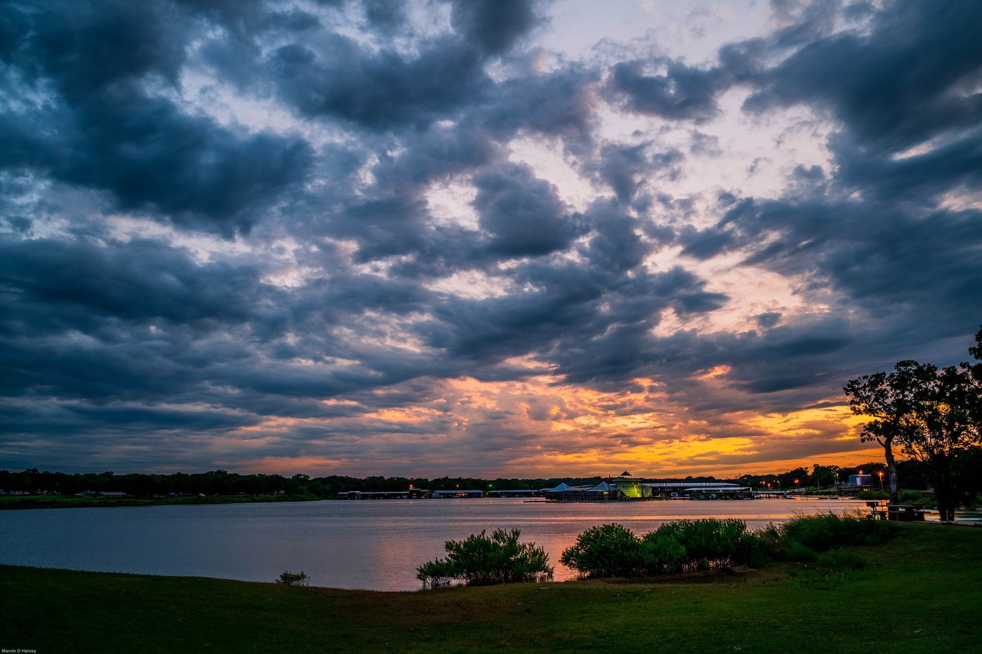 Sunset over a lake with dramatic clouds and a silhouetted shoreline
