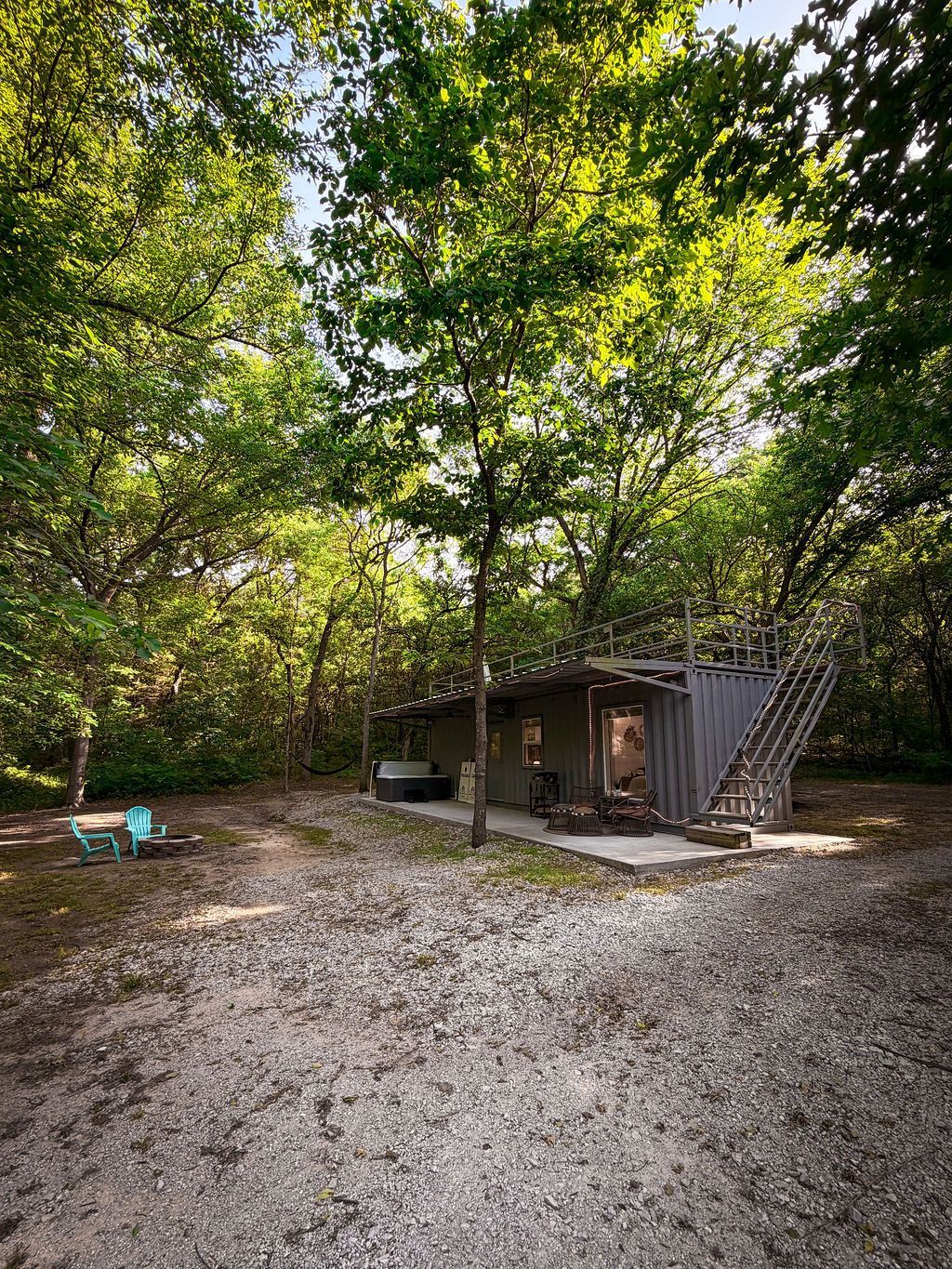 Wooded yard with a small shed and a staircase leading to an upper deck.