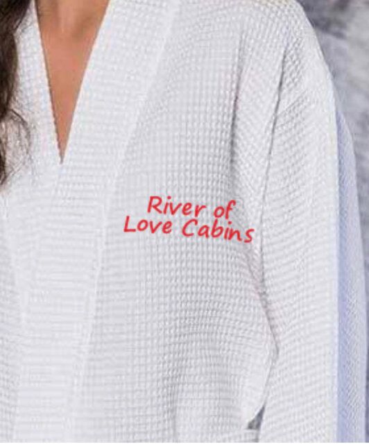 White waffle robe with red “River of Love Cabins” text on the chest