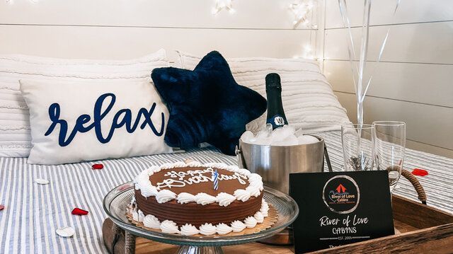 Relaxation spa setup with cake, candles, star pillow, and decorative signs on a striped cloth backdrop